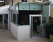Contemporary glass extension on wooden terrace