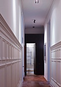 Narrow hallway with white-painted, half-height wood panelling