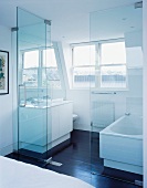 Glastrennwand vor Waschtisch und Badewanne im modernen weissen Bad