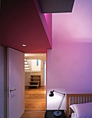 Bedroom with purple-painted ceiling elements above open door with view of stairs