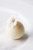 A white chocolate praline decorated with a candied daisy