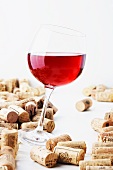 A glass of red wine with corks