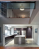 Blick in eine Küche mit Edelstahl-Küchenblock und auf das Obergeschoss