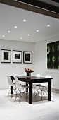 Simple dining room with dark table and white chairs