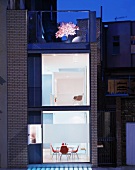 Blick auf eine beleuchtete Wohnung mit Dachterrasse