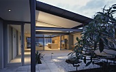 Terrace in front of contemporary house with view of illuminated interior