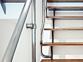 Detail of staircase with wooden treads and stainless steel balustrade