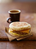 Sausage, Egg and Cheese Breakfast Sandwich on English Muffin; Cup of Coffee
