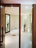 View through open wood and glass door into white designer bathroom