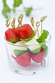 Tomato and mozzarella mini skewers with basil leaves