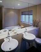 Runde Waschbecken unter Spiegelfront in modernem Bad