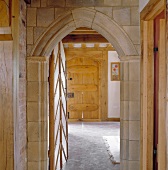 View into historic building through open door with pointed, masonry arch