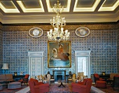Antique European furniture contrasting with traditional, North African wall mosaics in spacious foyer
