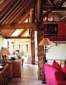 Various seating areas in barn converted into apartment with exposed roof timbers