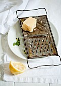 A piece of parmesan on a rusty grater