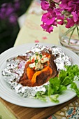 Baked sweet potato with chili butter in aluminum foil