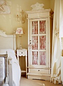 Glass-fronted cabinet with curtain in traditional, romantic bedroom