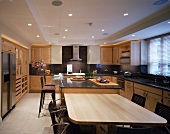 Dining area in front of kitchen counter with bar stools in open-plan kitchen