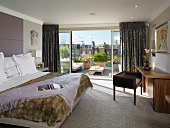 Modern bedroom with open, sliding glass doors and view of wooden terrace