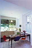 Colourful Bauhaus chairs in dining area in open-plan kitchen