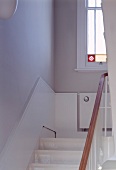 Detail of stairwell with half-height, white wood panelling