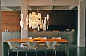 Dining table with modern chairs and unusual pendant light in loft flat