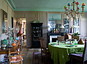 Dining room with vintage furniture, herringbone parquet flooring and green-painted ceiling