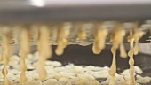 Grating spätzle dough into boiling water