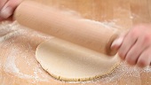 Dusting biscuit dough with flour and rolling it out
