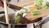 Placing finely chopped soup vegetables into a pan