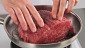 Sealing joint of beef in a frying pan