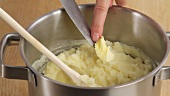 Butter being added to mashed potatoes