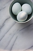 Three white eggs in a bowl