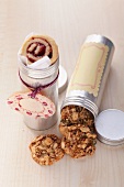 Cookies with mixed nuts and marmalade snails in aluminum tins