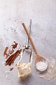 Cooking spoon, flat beater with batter on it and baking ingredients