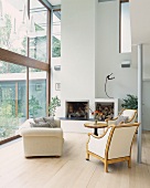 Retro armchair and couch in front of open fireplace in contemporary house