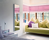 Modern sofa with scatter cushions in glazed bay window of bedroom
