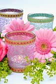 Various tea light holders decorated with flowers