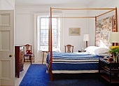Bedroom with canopied bed, blue bedspread & blue rug