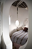 Schlüsselloch-förmiger Eingang zu liebevoll gestalteter Schlafkoje mit kleinen Fenstern und Stoffhimmel