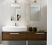 Dark wood washstand with counter-top washbasin in contemporary bathroom