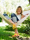 Young woman sitting in hammock smiling