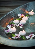 Floating, flaming tea lights in a metal bowl