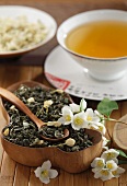Dried green tea with jasmine blossom and a cup of jasmine tea