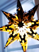 Sternförmige Laterne vor dem Fenster als Weihnachtsdeko