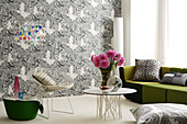 Mix of furniture styles in front of black and white patterned wallpaper