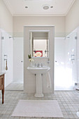 Renovated bathroom with pedestal washstand against partition and spacious shower area