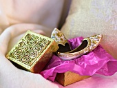 Moroccan gloves on violet paper and a decorated wooden box on a cushion