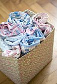 Nostalgic country house patterns in pale blue and pink - rolled bed linen in box covered with pattern of dog roses