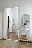 Ornate, antique, shabby chic washstand next to doorway leading to country house bedroom